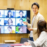 オフィス勤務とリモートワークのハイブリッドワークで会議をする従業員