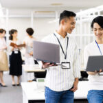 モバイルPCを片手に打ち合わせするデジタル人材の従業員